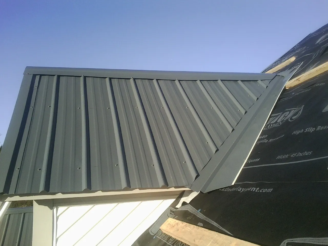 Gray metal roof panels going on over a garage gable in Lake Preston