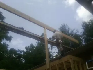 Carpenter setting a ridge beam over a new addition frame — Ice Dam Removal by Roofing Brothers in Lake Preston
