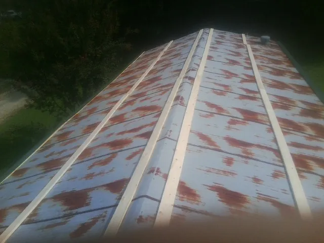 Rusted metal roof panels with new wood purlins before replacement — Storm Damage Roof Repair in Lake Preston by Roofing Brothers