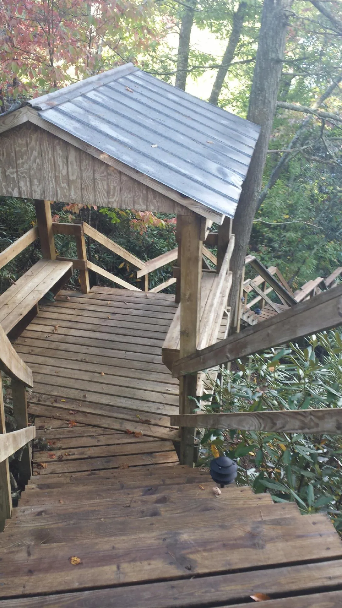 Metal roofed shelter over wooden steps on a wooded walkway — Skylight Repair & Installation work by our crew in Lake Preston